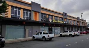 dois camiões brancos estacionados em frente a um edifício em One Avenue Hotel (IJM) em Bandar Indah