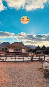 a fence in front of a building with a palm tree at Camp tala moon in Disah