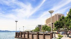 a pier next to a body of water with buildings at Disini Hotel in Kampong Sembulan