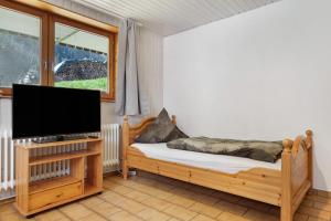 ein Schlafzimmer mit einem Bett und einem Flachbildfernseher in der Unterkunft Hugenhof in Kirchzarten