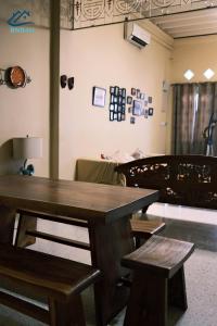 a table and benches in a room with a bed at City-Center Heritage Getaway for 12 Pax in George Town
