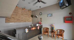 a living room with two chairs and a bar at I-Winton Hotel in Mentekab