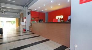 a coo counter in a restaurant with red walls at Capital O Ridel Hotel Kota Bharu in Kota Bharu