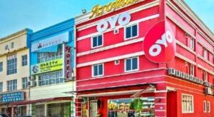 a red building with a stop sign in front of it at Hotel Aromas Kulai in Kulai