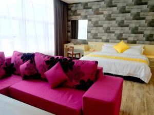 sala de estar con sofá rosa y cama en Kidurong Inn, en Bintulu 52 fotos más