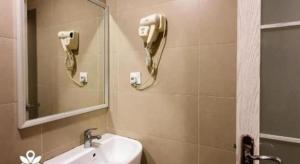 a bathroom with a sink and a phone on the wall at Capital O 90574 Hotel Glo in Kuala Lumpur