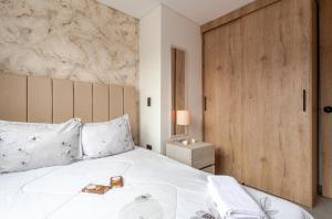 um quarto com uma cama branca com uma porta de madeira em apt 3 habitaciones em Rebolo