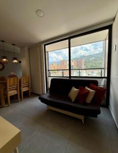 uma sala de estar com um sofá e uma janela grande em apt 3 habitaciones em Rebolo