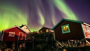 斯沃尔韦尔斯温诺亚罗布尔酒店的天空中一排有极光的小屋