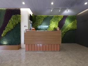 a plant covered wall in a room with a counter at TT Dorf Hotel (Taiping) in Taiping