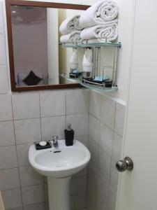 a bathroom with a sink and a mirror and towels at La Casarita in Manila +43 photos