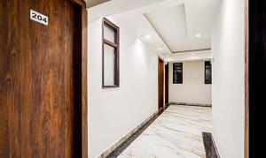 a hallway with a door with a sign on it at Golden Sky in Noida