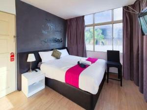 a bedroom with a bed and a chair and a window at OYO 90106 Sindbad Hotel in Kuala Lumpur