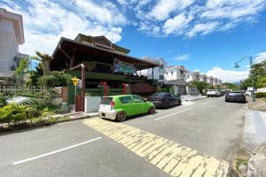 a green car parked in front of a building at OYO 90262 Kota Kinabalu Homestay, Villa & Suite Boutique in Kampong Guidan