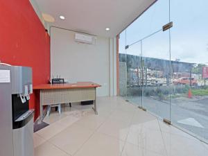a room with a desk and a red wall at OYO 90594 Hotel Casalink in Kampong Gong Gemia