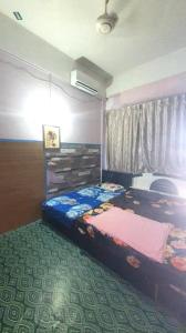 a bedroom with two beds and a window at Hotel O Penginapan Almera in Inanam