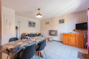 sala de estar con mesa con sillas y TV en Gite Clarabide, en Loudenvielle