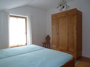a bedroom with a large bed and a wooden cabinet at Alpenpanorama vacation home in Bergen