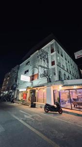 a motorcycle parked in front of a building at night at House Of Pattaya- Near Walking Street in Pattaya South