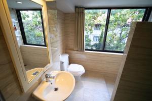 ein Badezimmer mit Waschbecken, Toilette und Spiegel in der Unterkunft Sawasdee House in Bangkok + 42 Fotos