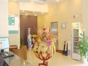 un vase rempli de fleurs posé sur une table dans l'établissement GreenTree Inn Zhoushan New Town Hotel, à Zhoushan