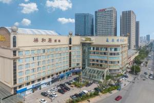 a large building with cars parked in a parking lot at Kunming Plateau Pearl Hotel in Kunming