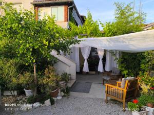 a patio with a white umbrella and some plants at Apartma REA Izola, pergola & terassa, parking in Izola