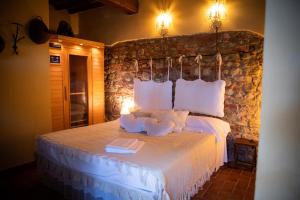 a bedroom with a bed with pillows and a stone wall at Podere Borgaruccio in Peccioli +90 photos