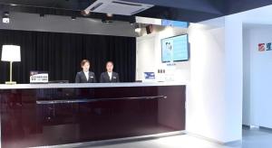 two men standing at a counter in a room at Jinjiang Inn Select Beijing Miyun Development Zone in Miyun