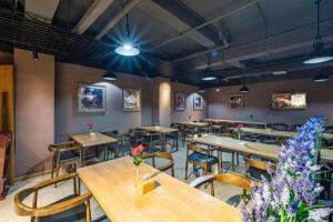 a restaurant with wooden tables and chairs and flowers at James Joyce Coffetel·Hengyang Jiefang Road Xianfeng Dock in Hengyang