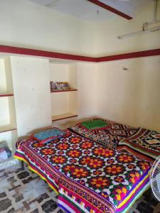 a bed in a room with a colorful blanket on it at Kutchi Niwas homestay dholavira in Dholovira