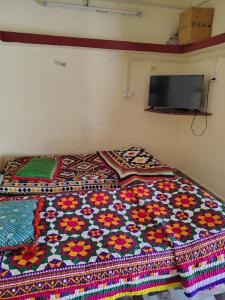 a bed with a colorful quilt on it in a room at Kutchi Niwas homestay dholavira in Dholovira