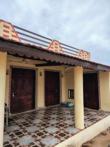 a house with two doors and a tiled floor at Kutchi Niwas homestay dholavira in Dholovira