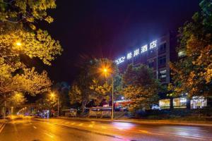 a city street at night with a building and street lights at Xana Hotelle· Dalian Software Park University of Technology in Dalian