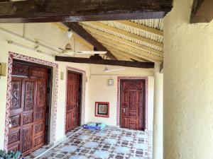 a room with two wooden doors and a tile floor at Kutchi Niwas homestay dholavira in Dholovira