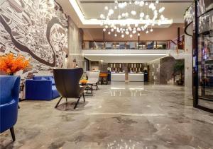Xingyin Wanfenglin AirportにあるEcharm Hotel Guizhou Xingyi Jushan Avenueの青い椅子とシャンデリアのあるロビー
