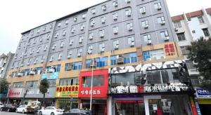 a large gray building on a city street with cars at Borrman Hotel Xiamen Xiang'an Maxiang in Xiang'an