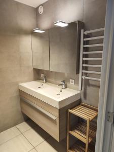 a bathroom with a sink and a mirror at Volledig gerenoveerd 2 slaapkamer appartement in Westende-Bad, 250 m van het strand in Westende Bad