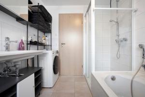 La salle de bains blanche est pourvue d'une baignoire, d'un lavabo et d'une douche. dans l'établissement Wohnung Sonnentau, à Bad Wurzach 15 autres photos