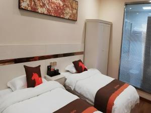 une chambre avec deux lits et une fenêtre dans l'établissement Jun Hotel Jiangsu Yangzhou Jiangdu District Xiaoji Town Yingtai Industrial Park, à Xiaoji