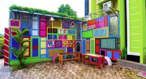 un bâtiment peint de différentes couleurs avec un banc dans l'établissement SPOT ON 2815 Hotel Damai, à Cilacap