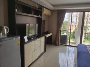 a living room with a tv and a large window at House Of Pattaya- Near Walking Street in Pattaya South