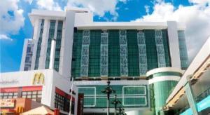 - un grand bâtiment avec des fenêtres vertes dans une rue de la ville dans l'établissement Big 8 Corporate Hotel Digos, à Aplaya