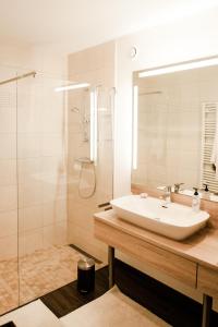 ein weißes Bad mit einem Waschbecken und einer Dusche in der Unterkunft Appartement Hauser Kaibling in Haus im Ennstal
