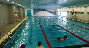 a group of people swimming in a swimming pool at Shanghai Manhattan Hotel Minhang in Shanghai