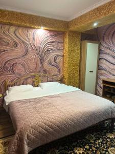 a bedroom with a bed with a colorful wall at Golden Rose in Chişinău