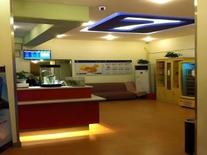 a lobby with a waiting room with a couch and aperature at 7 Days Inn Guangzhou Huangpu East Zone Times Plaza in Guangzhou