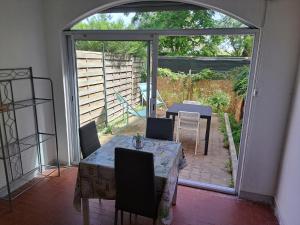 ein Esszimmer mit einem Tisch und Stühlen sowie eine Terrasse in der Unterkunft Cap City, modeste rez-de-jardin 500m plage et du Port in Cap d'Agde