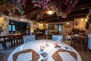 a dining room with tables and chairs and flowers at Spino Fiorito Stay in Casola in Lunigiana