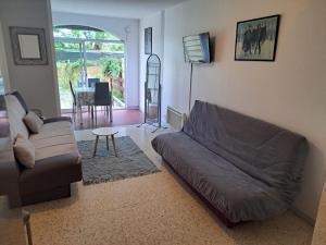 ein Wohnzimmer mit Sofa und Tisch in der Unterkunft Cap City, modeste rez-de-jardin 500m plage et du Port in Cap d'Agde